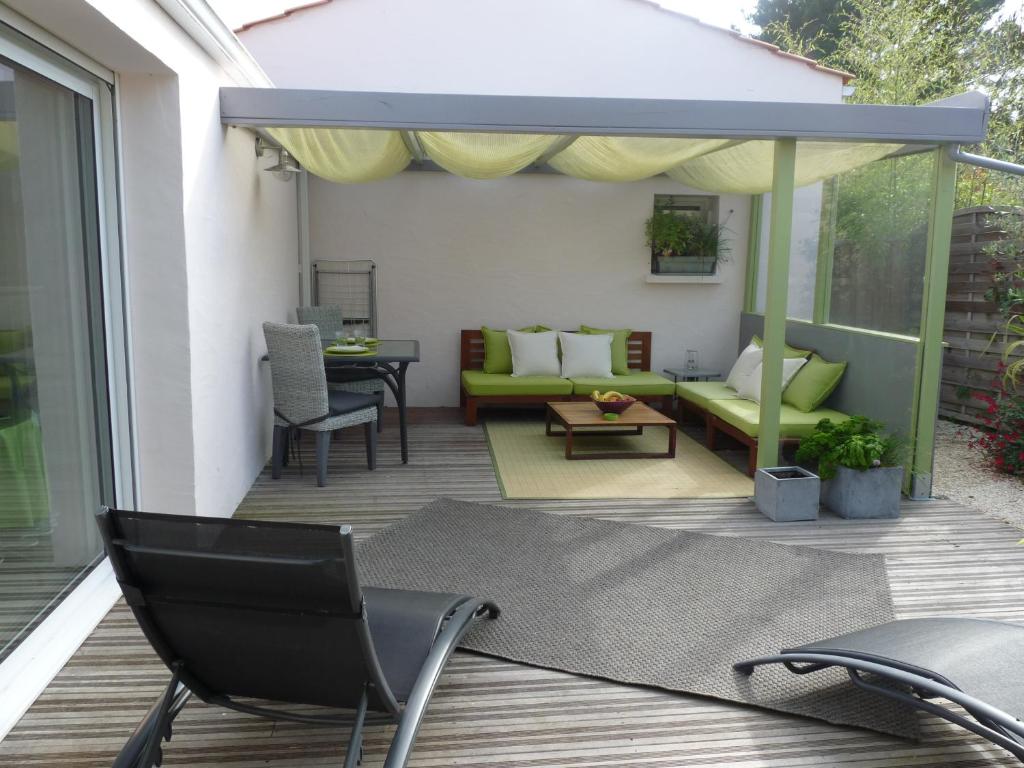 un patio con sofá y una silla en una terraza en l'allerie studio en Les Sables-dʼOlonne