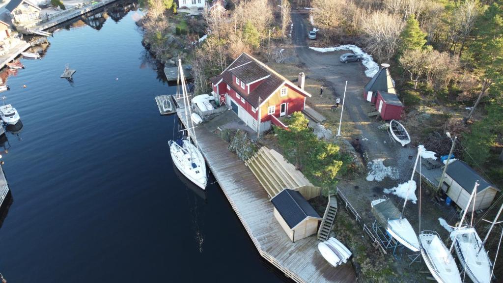 una casa su un molo con una barca in acqua di Flekkerøy 20 persons a Kristiansand
