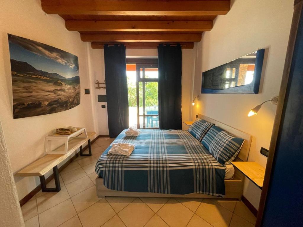 1 dormitorio con cama y ventana en La FIOCCHINA - Magic Place - apartments & studios in Garda Lake - countryside farmhouse, inside the middle of the lake, en Saló