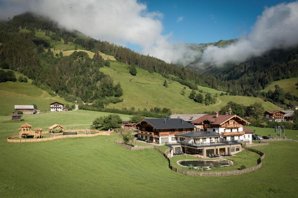 an aerial view of a house in a green field at Schmiedhof Gut in Grossarl