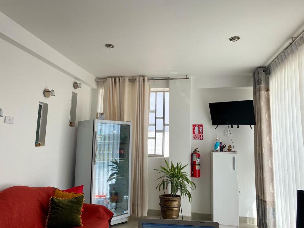 sala de estar con sofá rojo y ventana en Hotel Munay, en Paracas