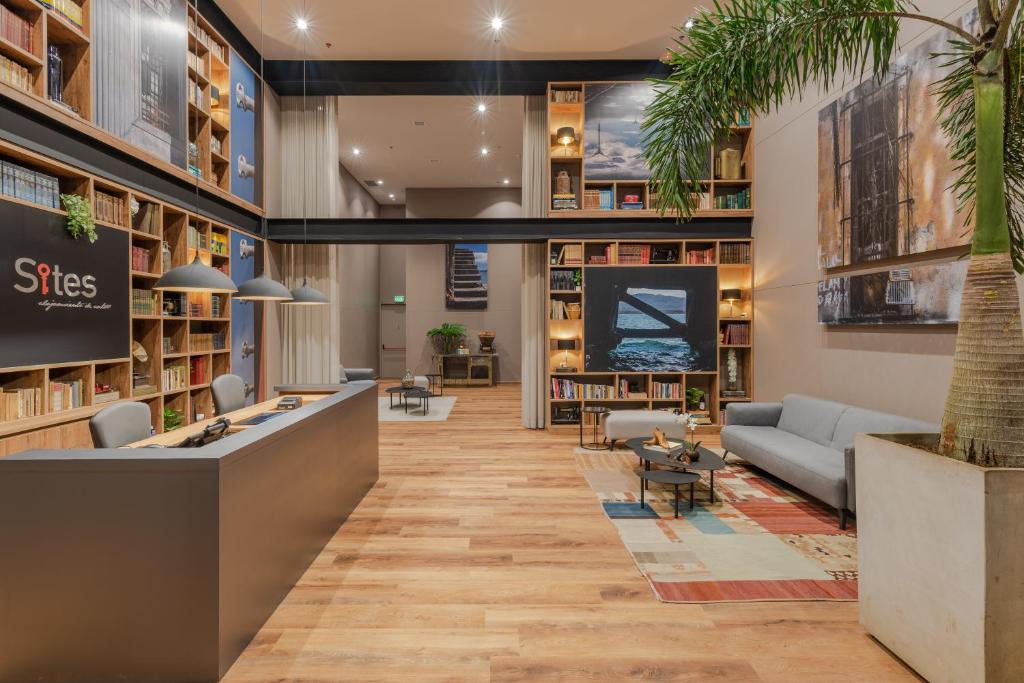 - un hall d'une bibliothèque avec des canapés et une table dans l'établissement Hotel Sites Barranquilla, à Barranquilla