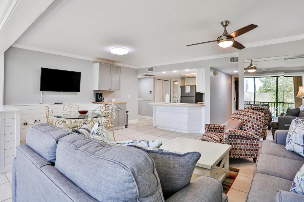 uma sala de estar com dois sofás e uma cozinha em Midnight Cove II 823 em Siesta Key