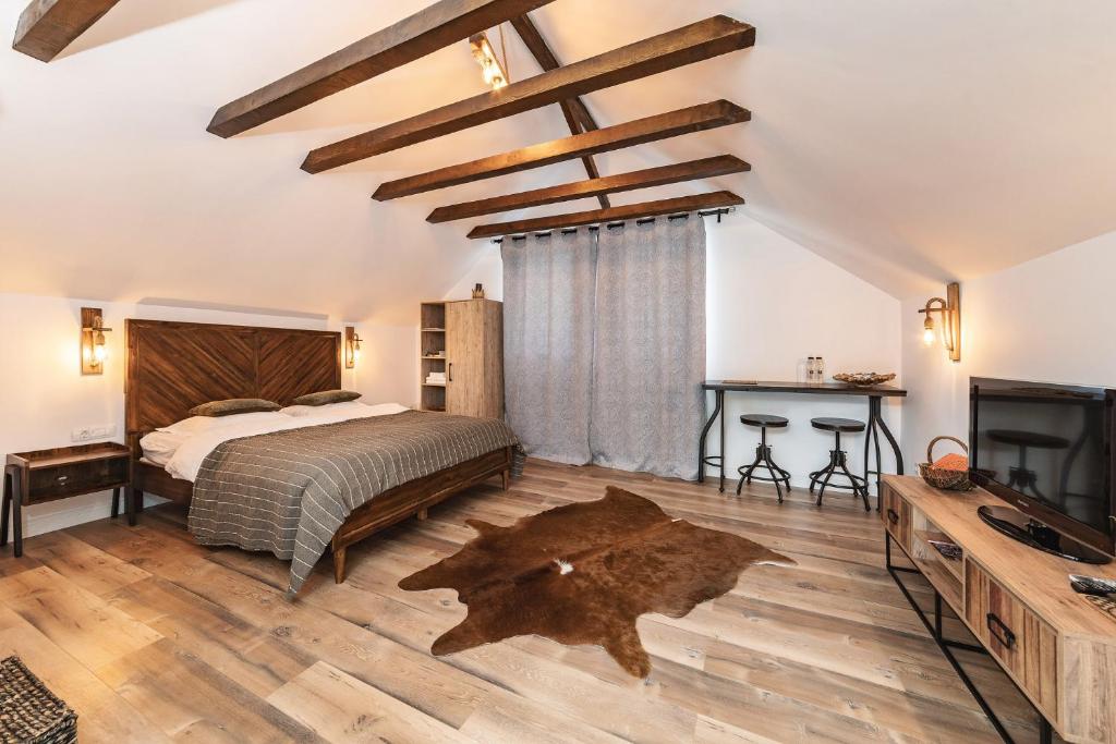 a bedroom with a bed and a tv on a wooden floor at Natura Magura in Buzău