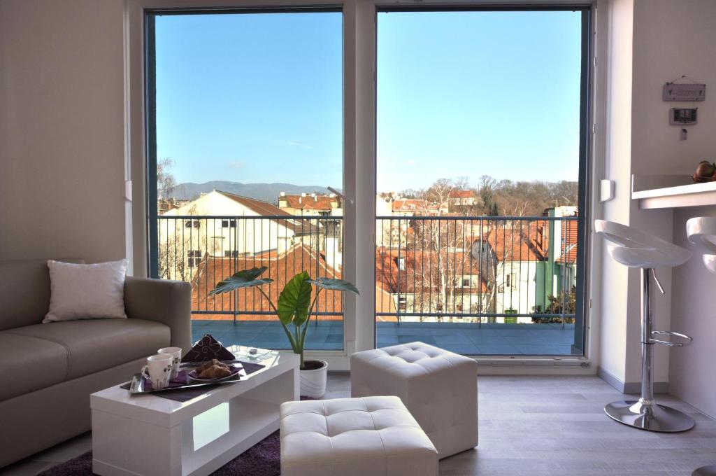 a living room with a couch and a large window at Bellevue Apartment in Zagreb
