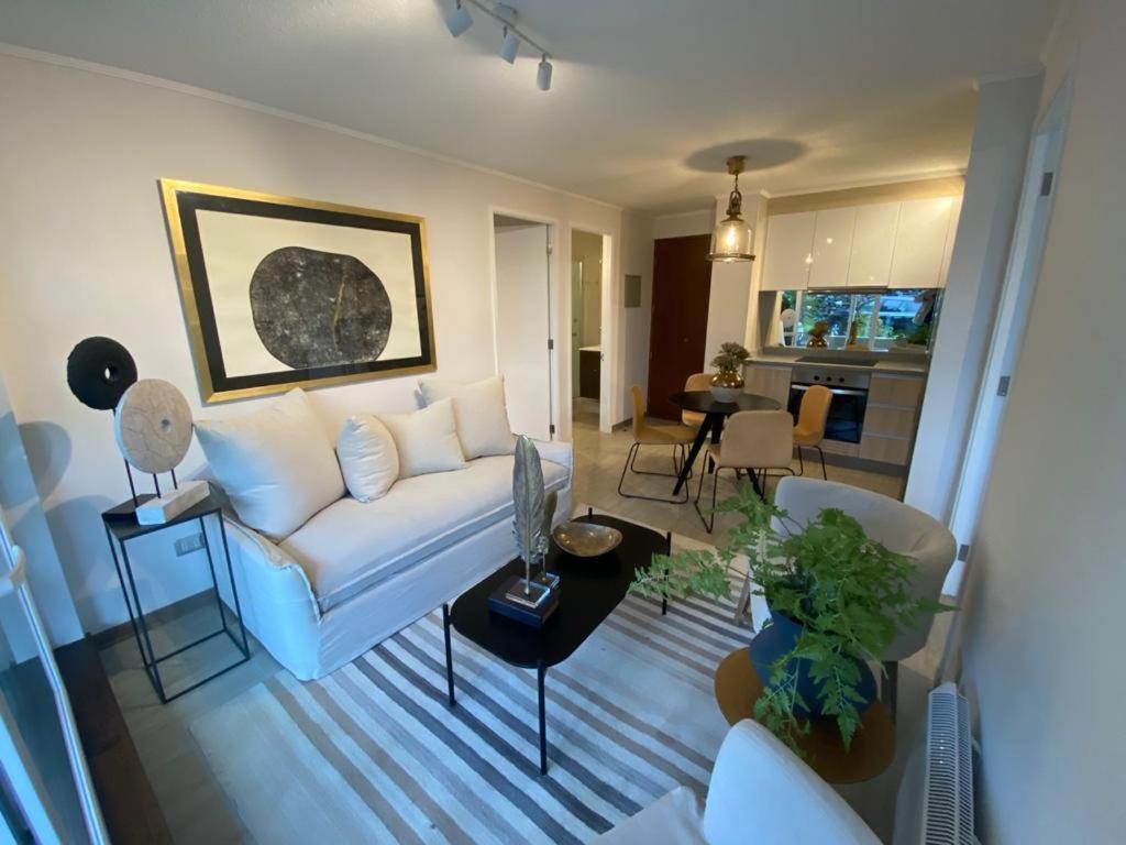 a living room with a white couch and a table at Departamento Pucon in Pucón