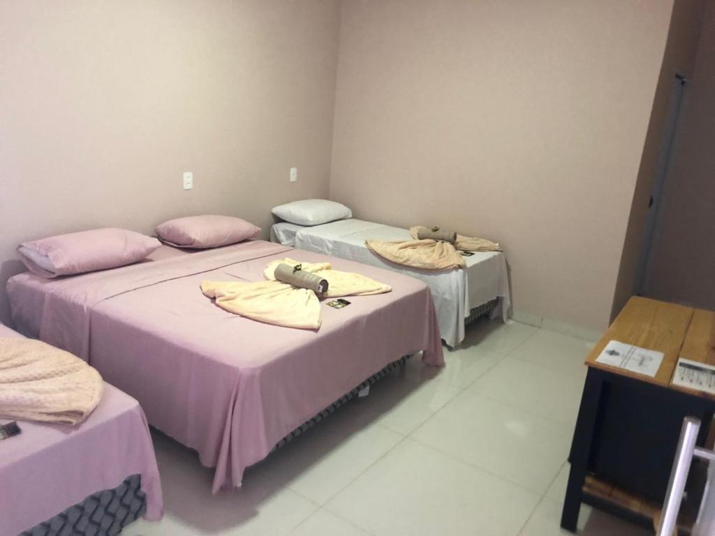 a room with two beds with towels on them at Pousada Amanhecer no Jalapão in São Félix do Tocantins
