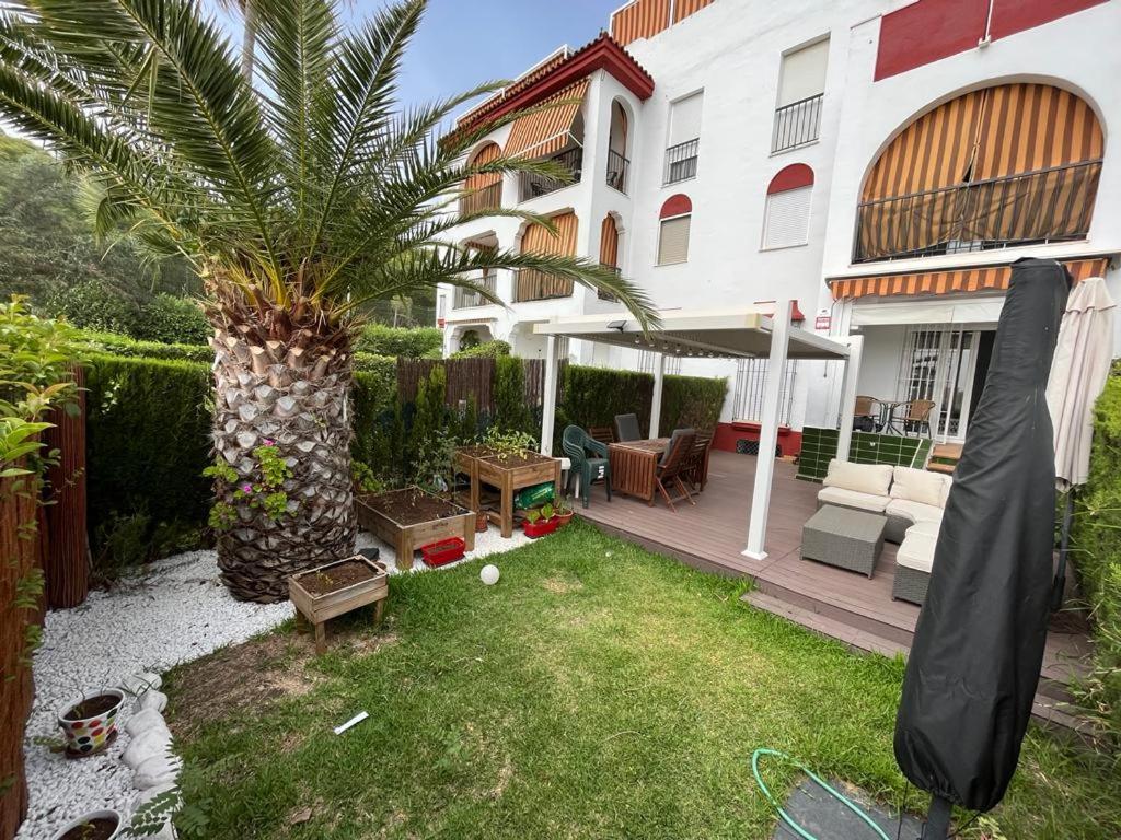 une cour avec un palmier en face d'un bâtiment dans l'établissement Precioso apartamento con ubicación perfecta en playa Islantilla, à Islantilla