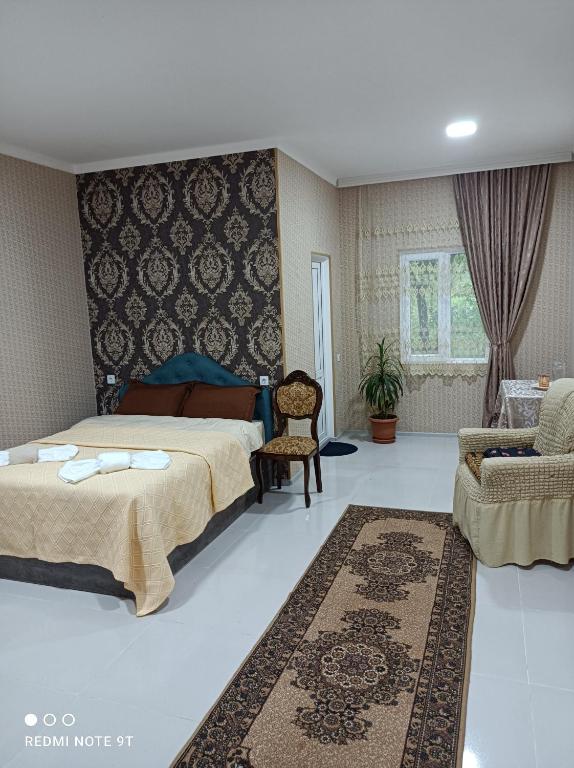 um quarto com uma cama, um sofá e uma cadeira em zaza house em Kutaisi