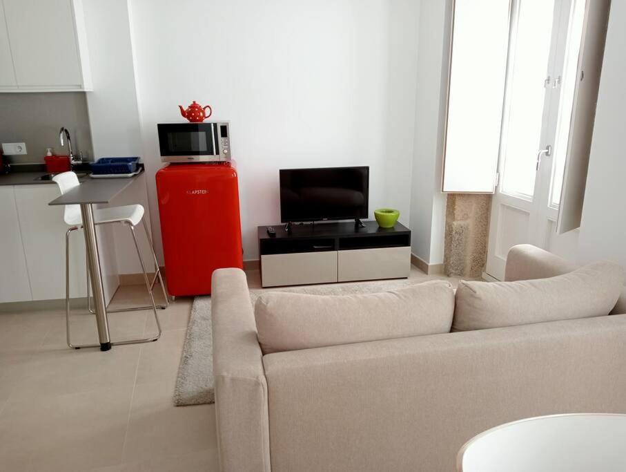 a living room with a couch and a tv in it at Apartamentos Tras dos Fornos in Chantada