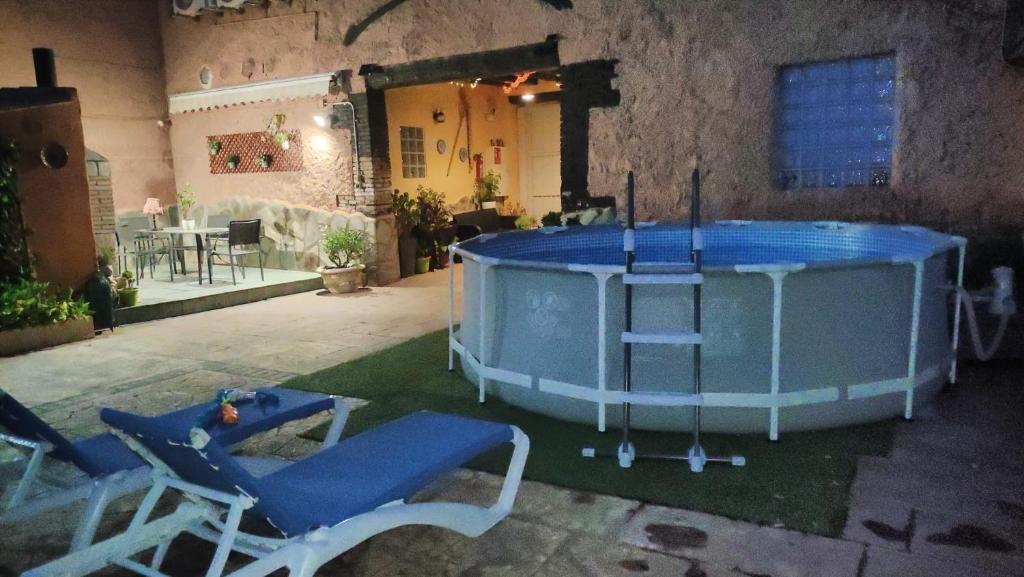 a blue pool with two chairs and a table at La Palmera de la Insula in Alcalá de Ebro