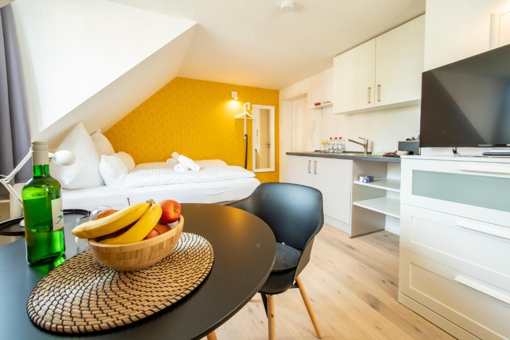 Una habitación con una mesa con un bol de fruta y una cama en Gästehaus am Schlossplatz Z. 3, en Meersburg