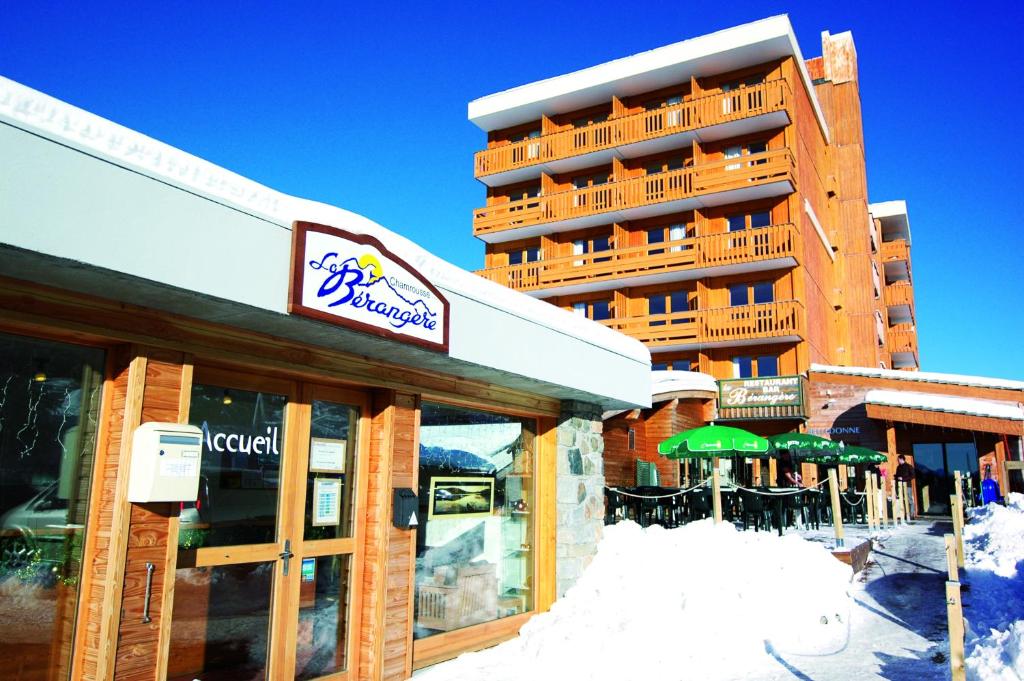 un hotel con nieve en el suelo frente a un edificio en La Berangere, en Chamrousse