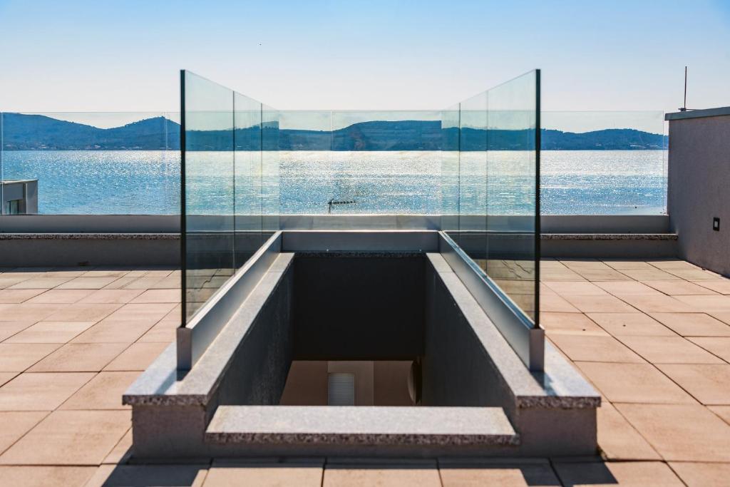 a swimming pool on the roof of a building with a glass wall at Luxury penthouse Marina - Sukošan in Sukošan