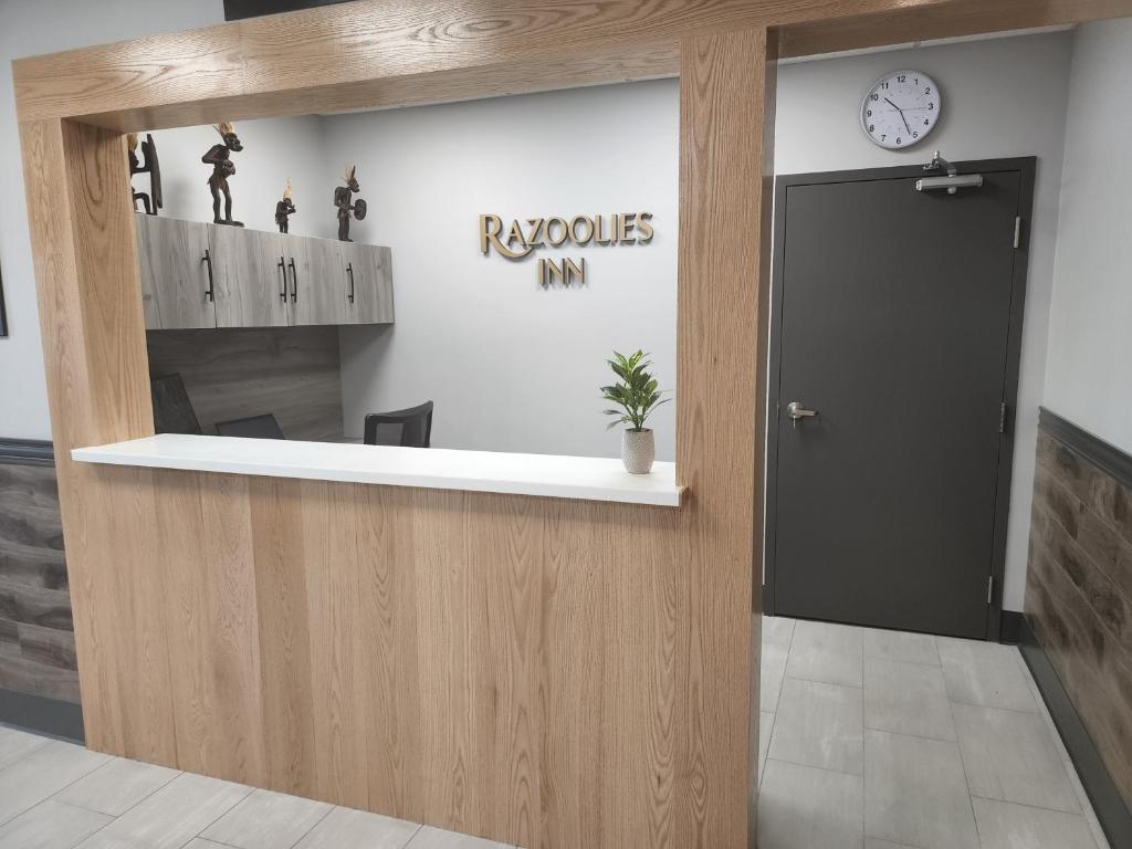 a lobby with a reception desk with a clock on the wall at Razoolies Inn in Stephenville