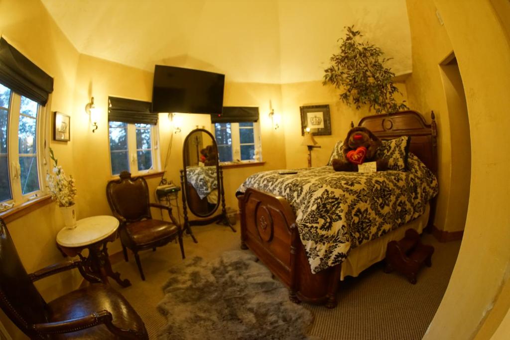 Schlafzimmer mit einem Bett, einem Tisch und Stühlen in der Unterkunft FLEUR DE LAC EUROPERAN INn in Lake Arrowhead