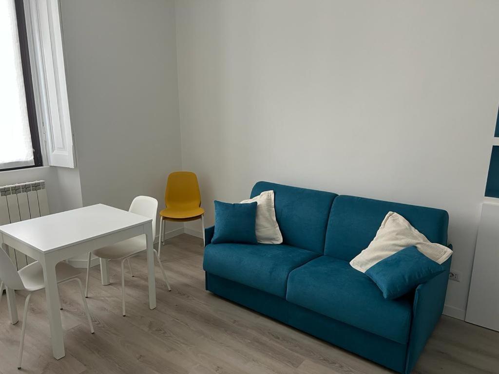 un salon avec un canapé bleu et une table dans l'établissement PRESTIGE BOUTIQUE HOMES - Arco della Pace 2, à Milan