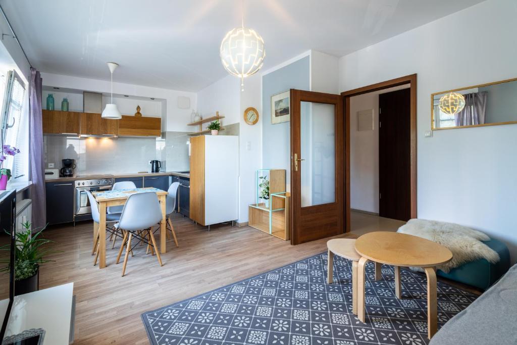 uma sala de estar e uma cozinha com mesa e cadeiras em Apartament Scandi em Gdynia