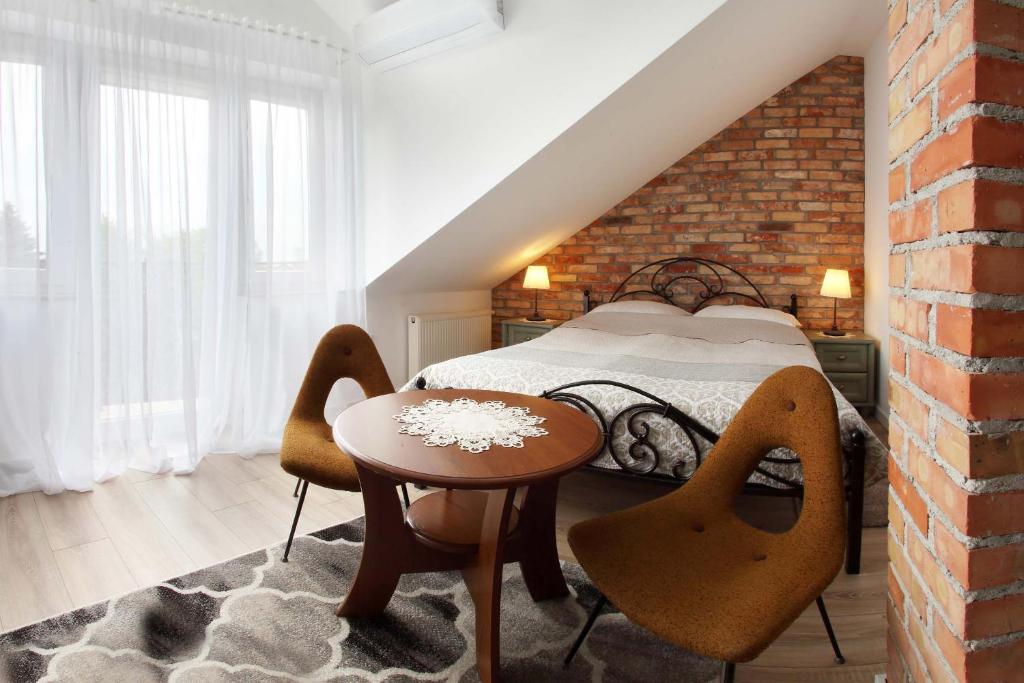a bedroom with a bed and a table and chairs at Bryza in Łeba