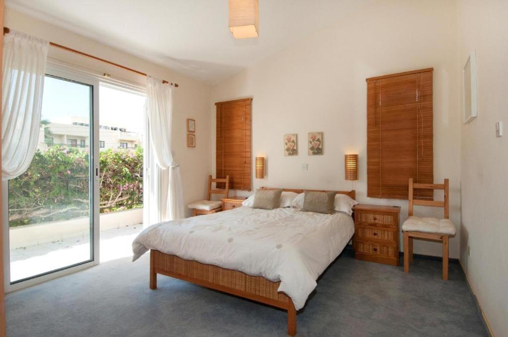 - une chambre avec un grand lit et une grande fenêtre dans l'établissement Coral Bay Beachfront Paradise Villa Private Pool, à Coral Bay