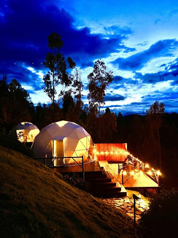a group of tents on a hill at night at Golden Glamping in Guatavita