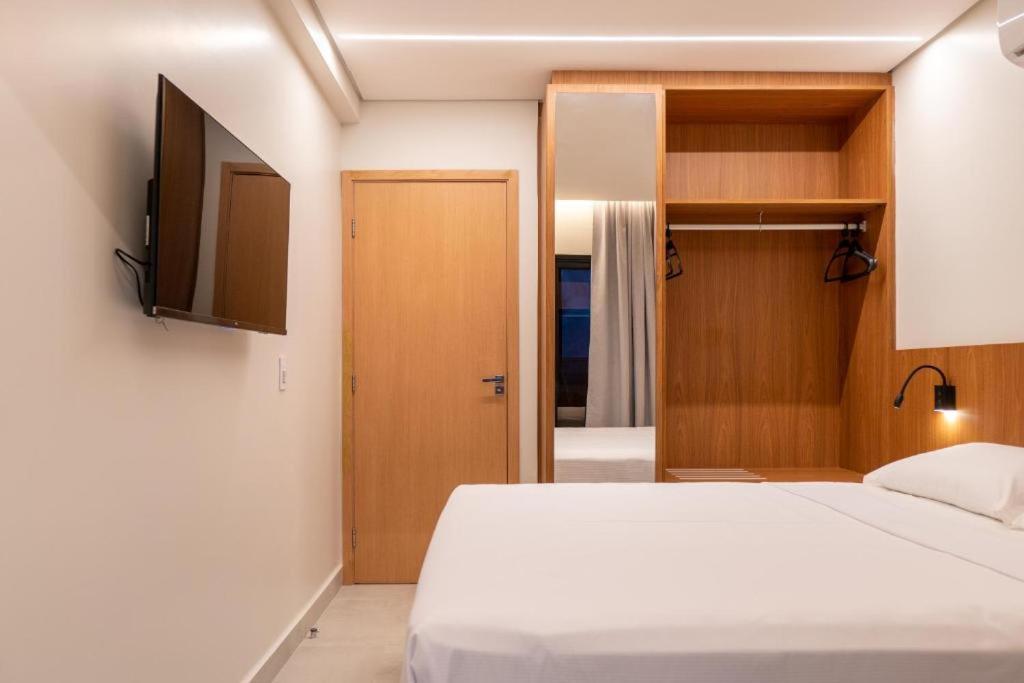 a bedroom with a white bed and a television at Apartamento Vista Mar Salinas Premium Resort in Salinópolis