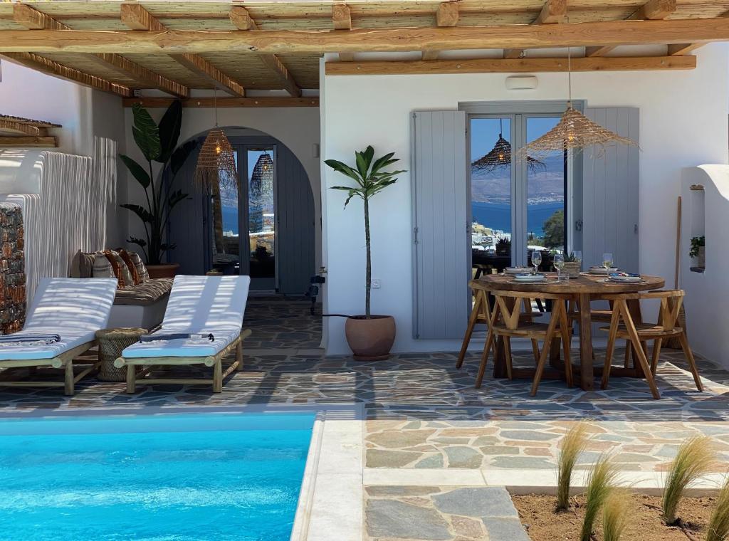 a villa with a swimming pool and a table and chairs at Beachhouse Omega Naxos in Agia Anna Naxos