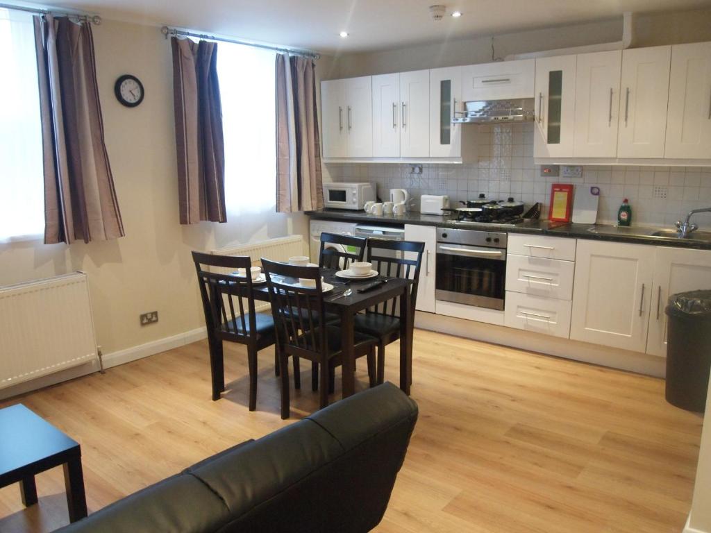 a kitchen and dining room with a table and chairs at Marble Arch Flats in London