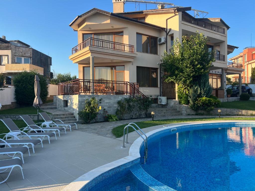 a house with a swimming pool in front of a house at Family Hotel Dreams in Sozopol