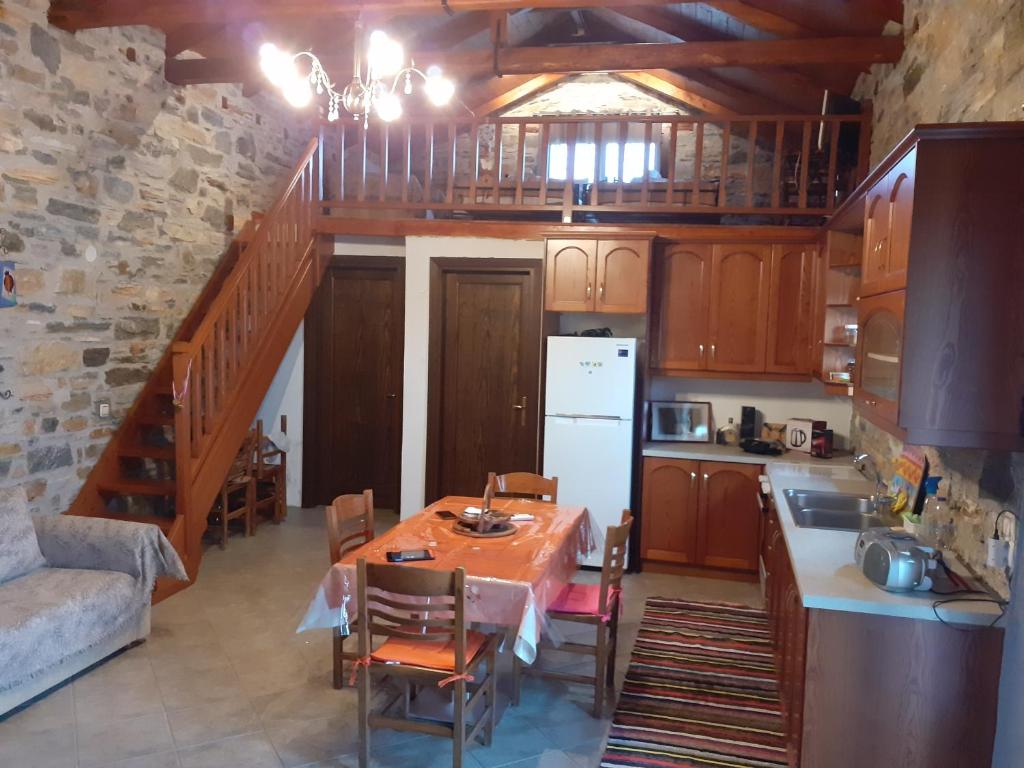 a kitchen with a table and a kitchen with a staircase at LIMNIONAS SUNVIEW in Xorychti