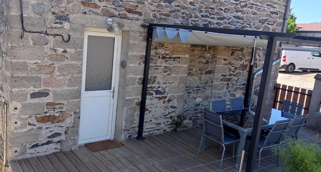 a patio with chairs and an umbrella and a building at Git'a'Gnac in Retournac