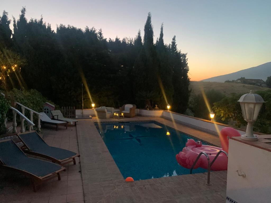 una piscina con sillas y una puesta de sol en el fondo en villa Cerro del Aguila, en Mijas Costa