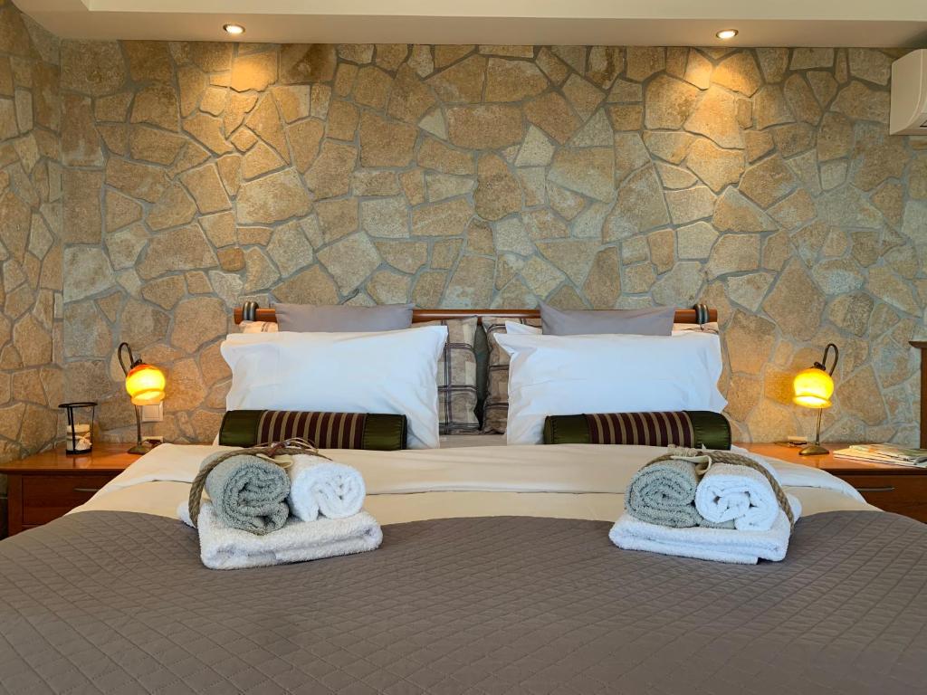 ein Schlafzimmer mit 2 Betten und Handtüchern darauf in der Unterkunft DoorMat# Wait 'N Sea, Jacuzzi, Luxury Stone House in Epanomi