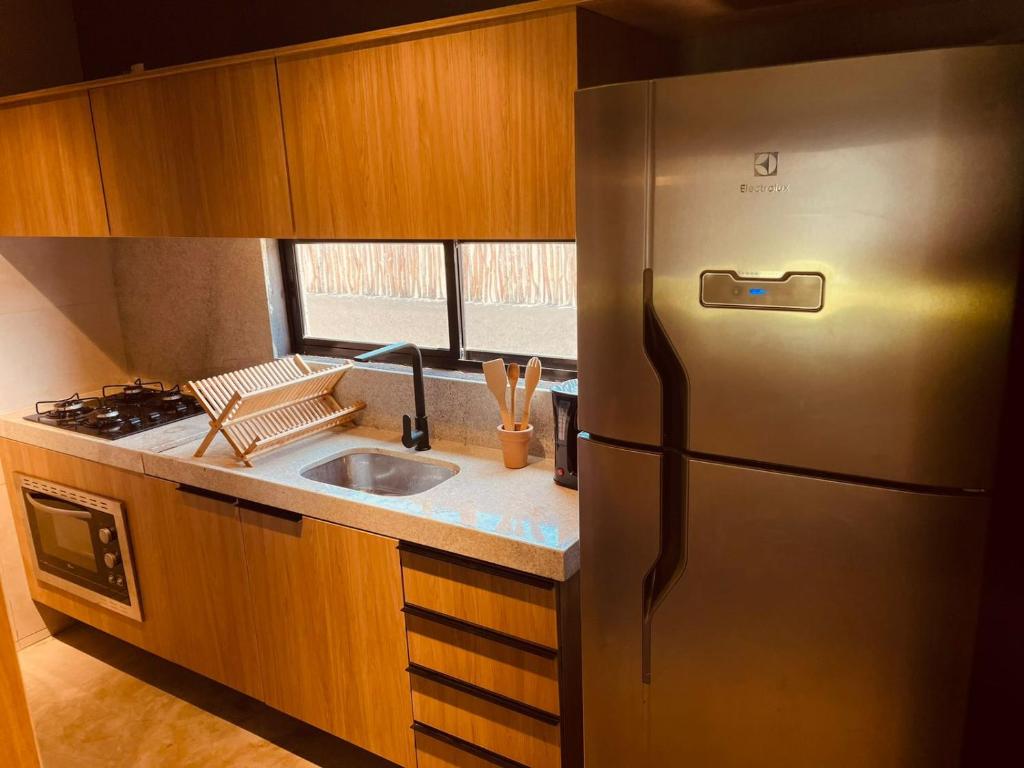 a kitchen with a stainless steel refrigerator and a sink at 7 ESTRELAS PATACHO in Pôrto de Pedras