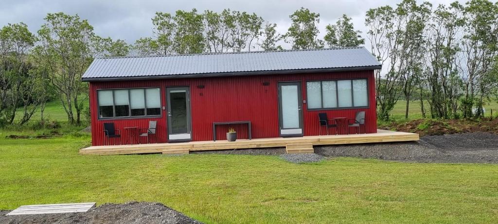 a red tiny house on a wooden deck at New and well furnished studio apartment for two 30 km from Kirkjubæjarklaustur Perfect place to stay at right between Black beach and Jökulsárlón in Kirkjubæjarklaustur