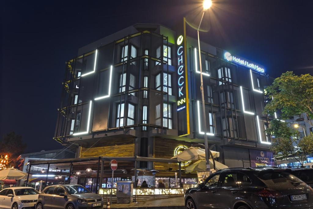 a building with cars parked in front of it at night at Check Inn Suite Hotel & SPA in Ankara