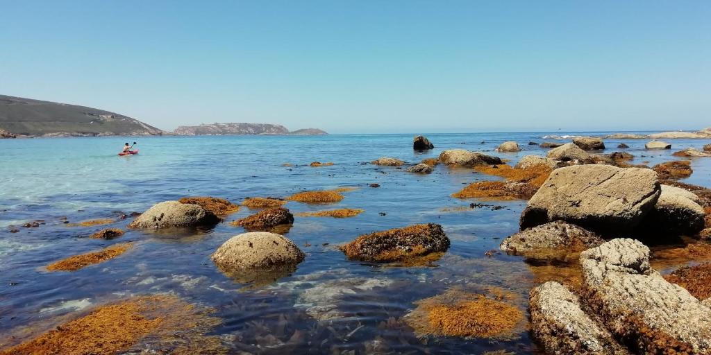 un grupo de rocas en el agua en una playa en Hostal J.B en Malpica