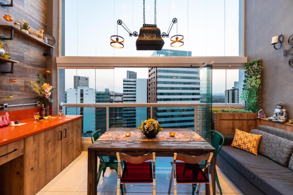 a kitchen with a table and a large window at Edificio Summit Pinheiros Best Location in São Paulo Balcony with City Views Pool, Fitness Room and Parking Garage 3 minutes to Subway in Sao Paulo