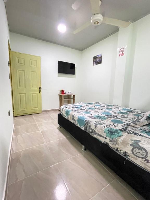 een slaapkamer met een bed en een groene deur bij RIO Colors - Hospedaje in Barrancabermeja