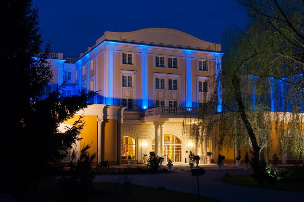 un edificio con luces azules por la noche en Hotel Windsor w Jachrance en Jachranka