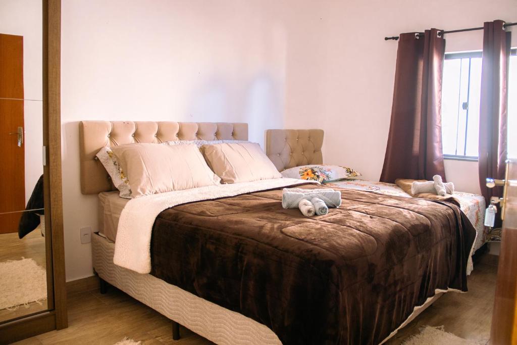 Un dormitorio con una cama grande con dos animales de peluche. en Pouso Primavera en Tiradentes