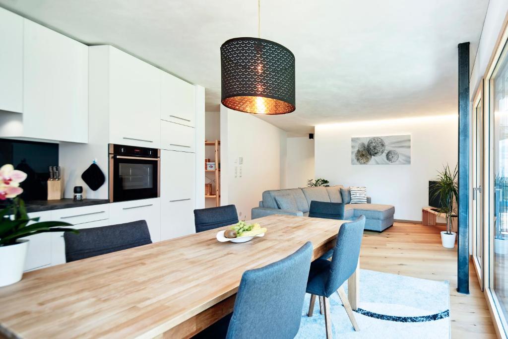 kuchnia i salon z drewnianym stołem i niebieskimi krzesłami w obiekcie ROTUND-Nature_Mountain_Living w mieście Tubre