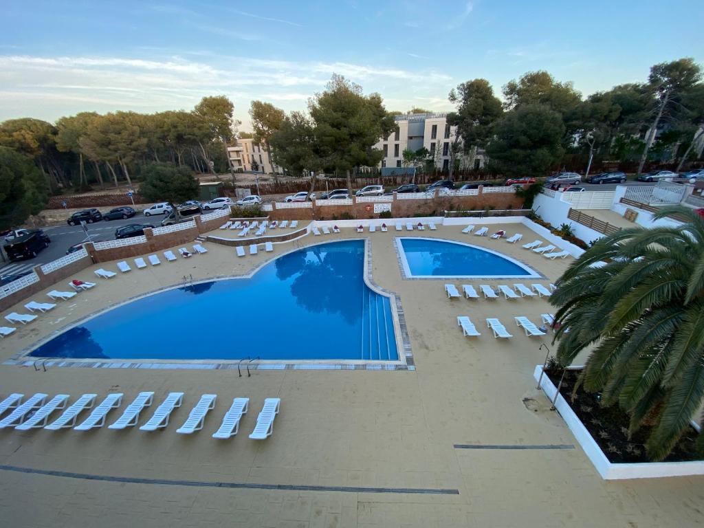 una vista aérea de una gran piscina con tumbonas en Apartamento con servicios, piscina y parking privado máx 4 pax, en Salou