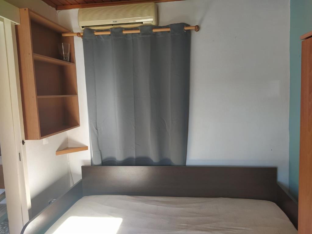 Posto letto in una piccola camera con tenda di Ilias apartment a Heraklion