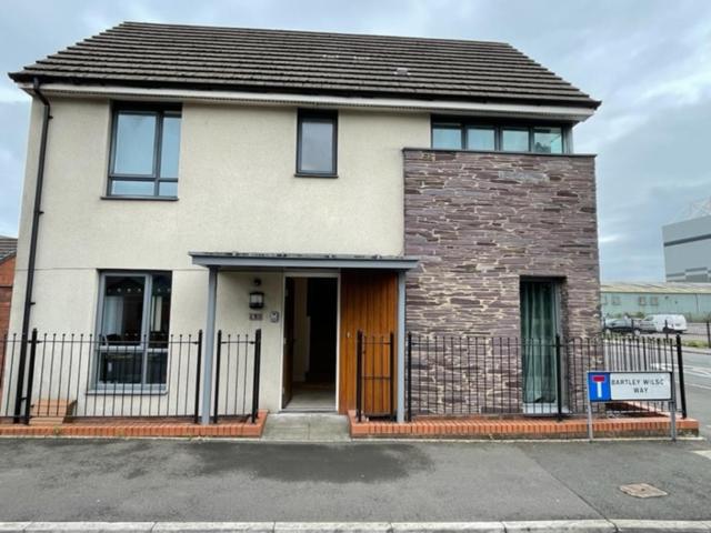 a white house with a brown door and a fence at Holiday Home In Cardiff. Sleeps 6 in Cardiff