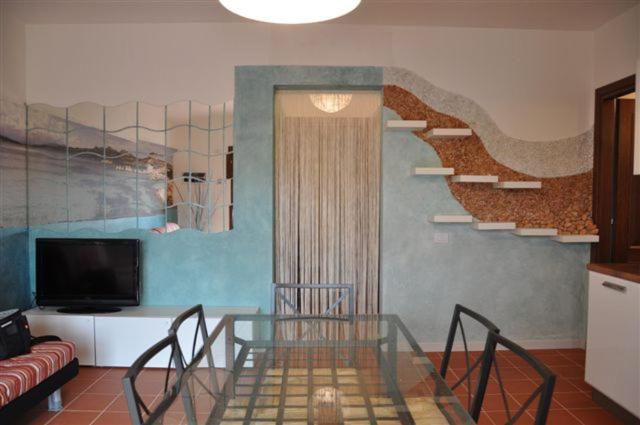 a living room with a glass table and a couch at La Casa Degli Specchi-villetta con due giardini in La Maddalena