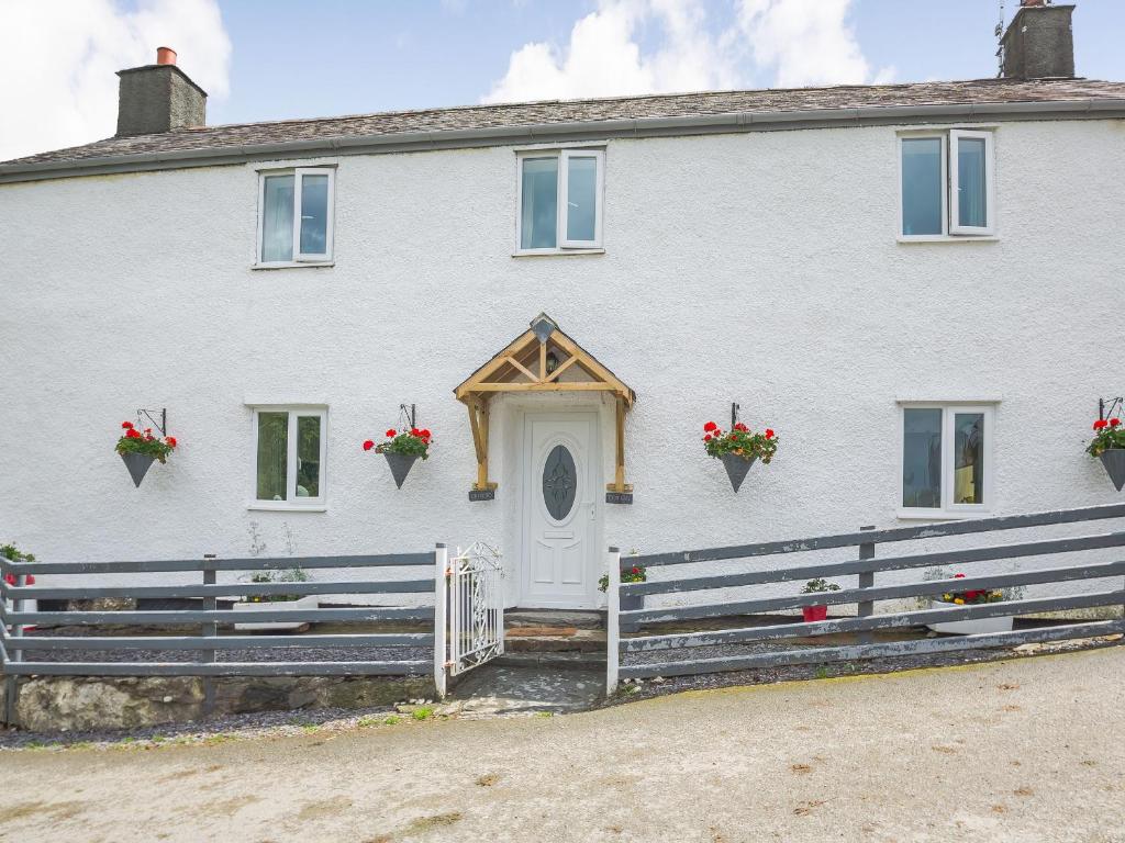 a white house with a white door and a fence at Ty Nant in Llanrwst