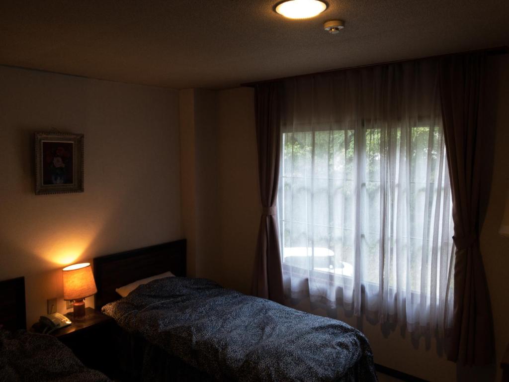 Postel nebo postele na pokoji v ubytování NAEBA KOGEN HOTEL