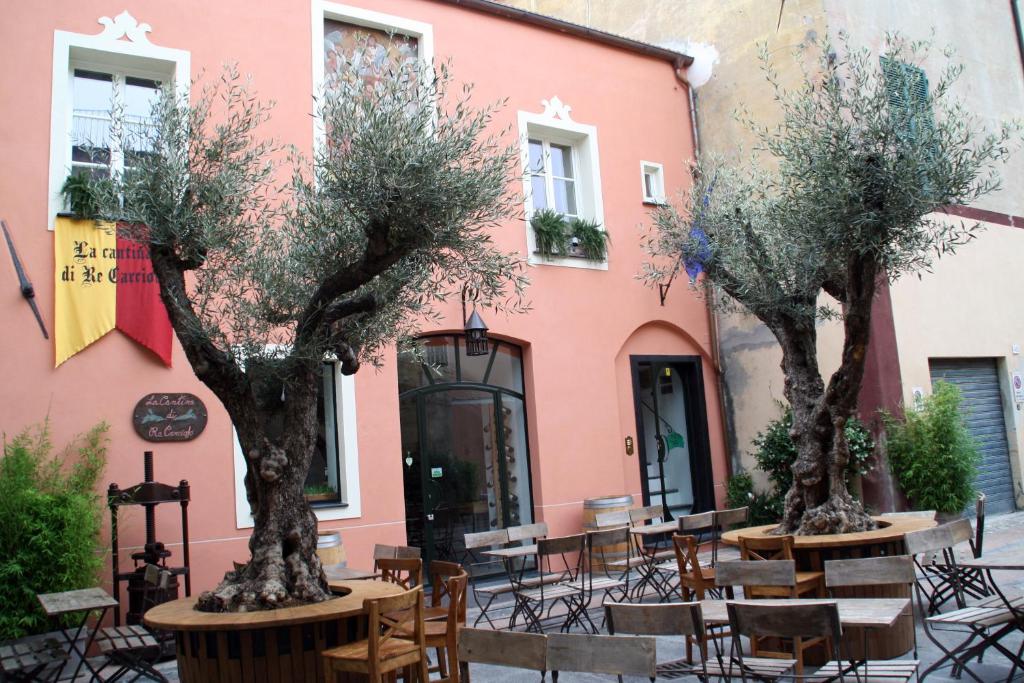 two trees in front of a pink building at La dimora del Conte Bracco B. in Albenga