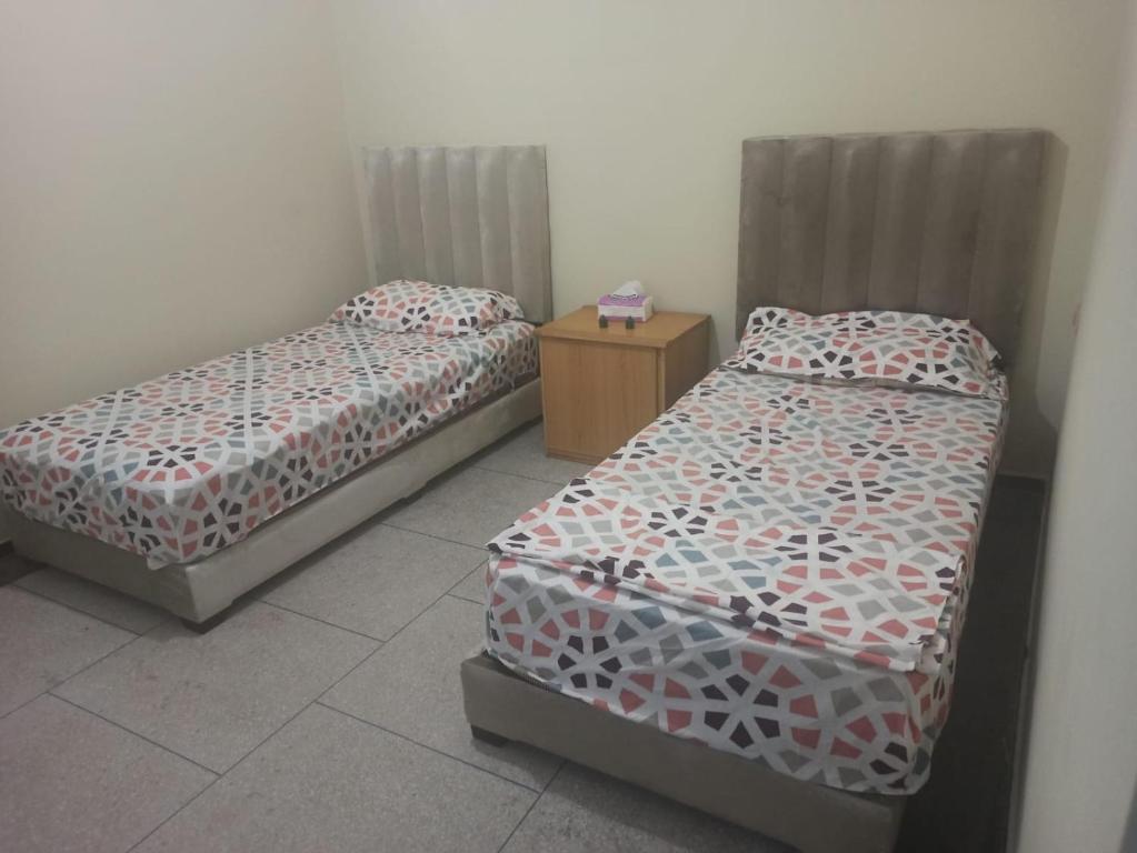 Habitación con 2 camas y mesita de noche en Quartier Anne Marie, en Temara